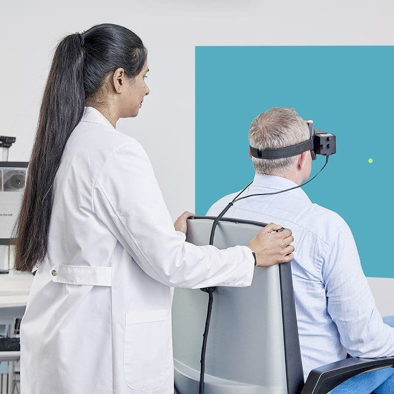 Kliniker udfører en cervikal-okulær test på en patient, der sidder i Orion Reclining rotatorstolen og har VisualEyes VNG-briller på.